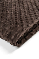 Folded brown textured blanket on a white background