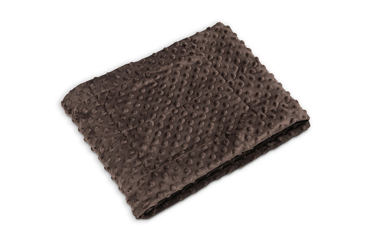Folded brown textured blanket on a white background
