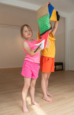 girls holding up hight a tactile sensory snake 