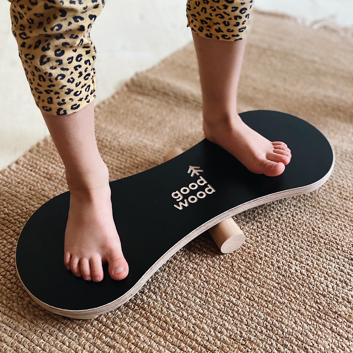 A GIRL BALANCING ON THE BLACK BALANCE BOARD / TRICK BOARD FOR KIDS- GOOD WOOD