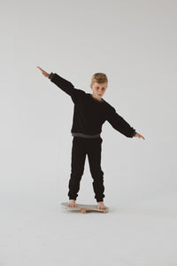 A BOY BALANCING ON THE BALANCE BOARD / TRICK BOARD FOR KIDS- GOOD WOOD